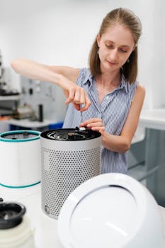 Close-up of a young woman using a screwdriver to repair an air purifier in a laboratory environment.